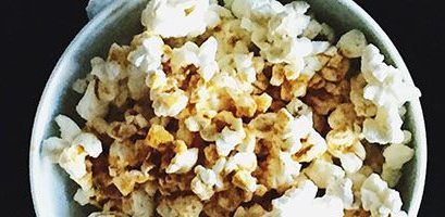 Hand Grabbing Popcorn From Three Tubs